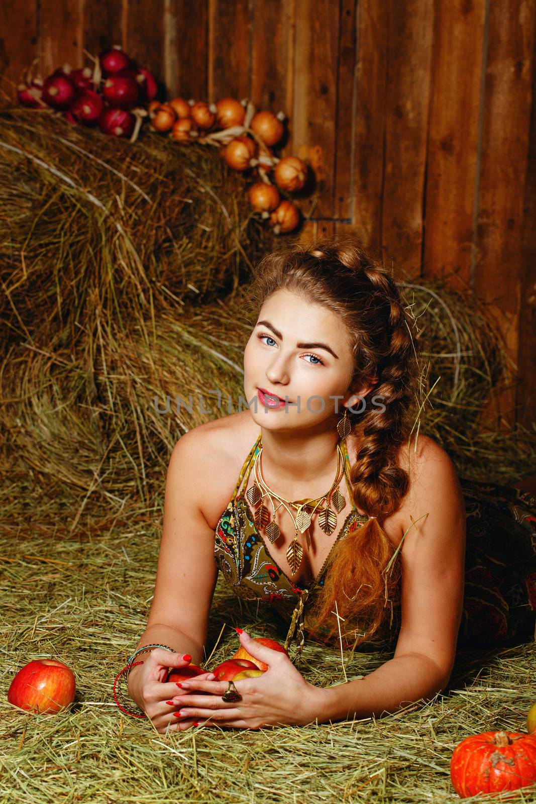 Attractive young rural girl in the hayloft after harvest festival