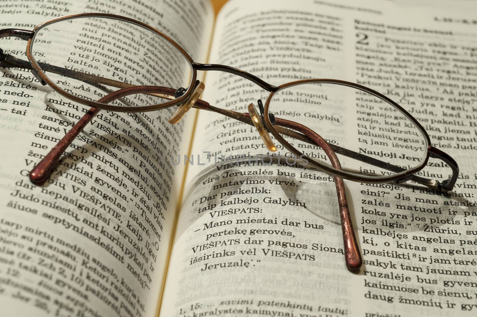 Round glasses lie on the bible in the Swedish language