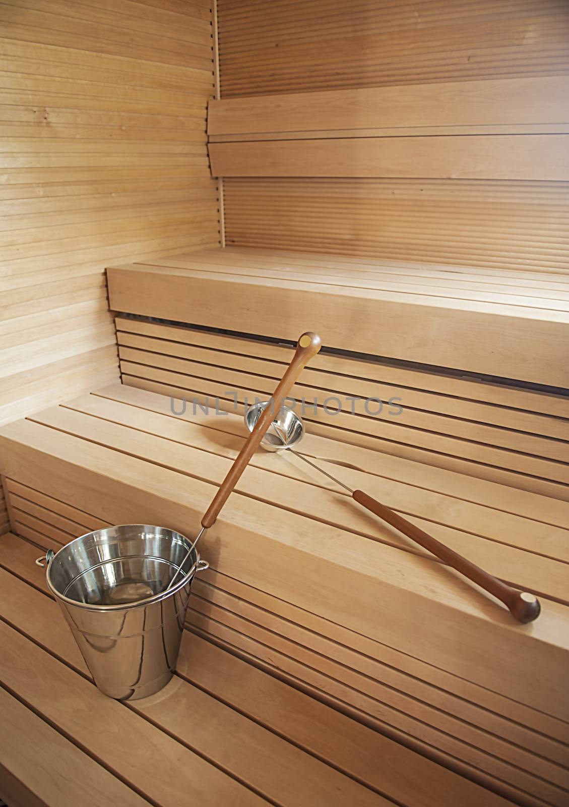 Bucket and scoop in wooden finnish sauna background.