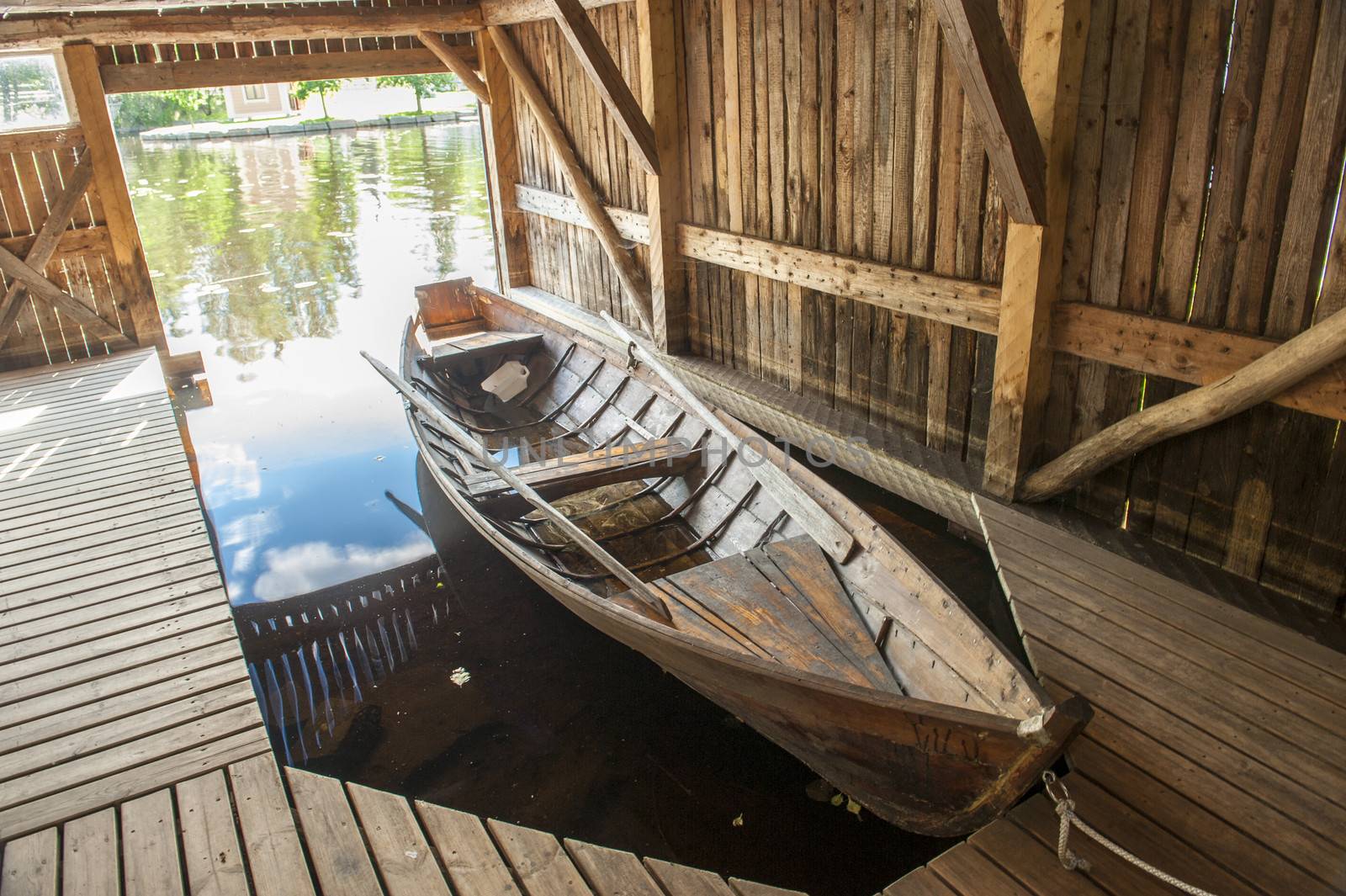 Wooden boat in the pier under canopy. Taken in Finland.