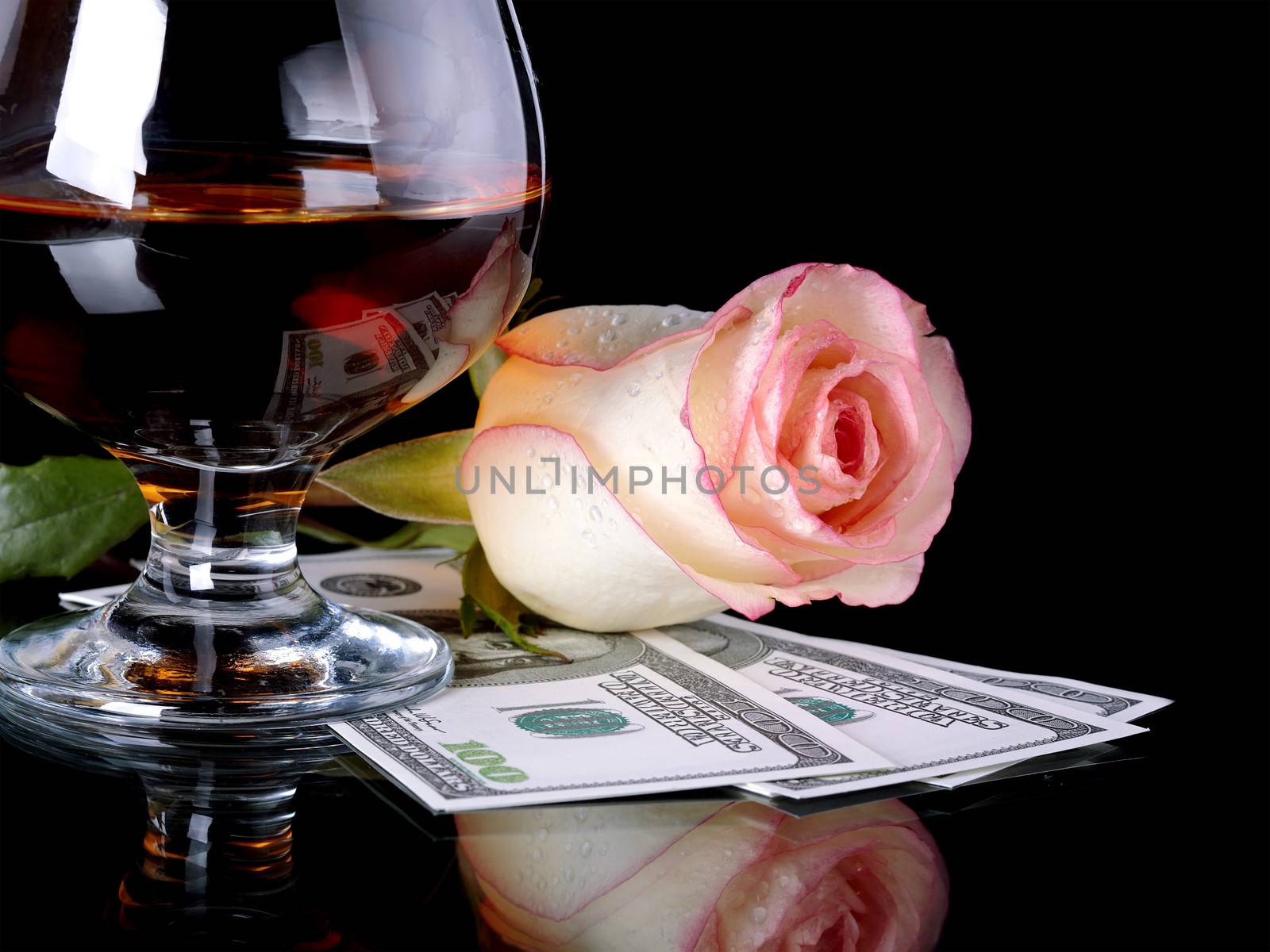 Glass, rose and money. Alcohol, flower and dollars. Glass with drink and a pink rose with dollars.
