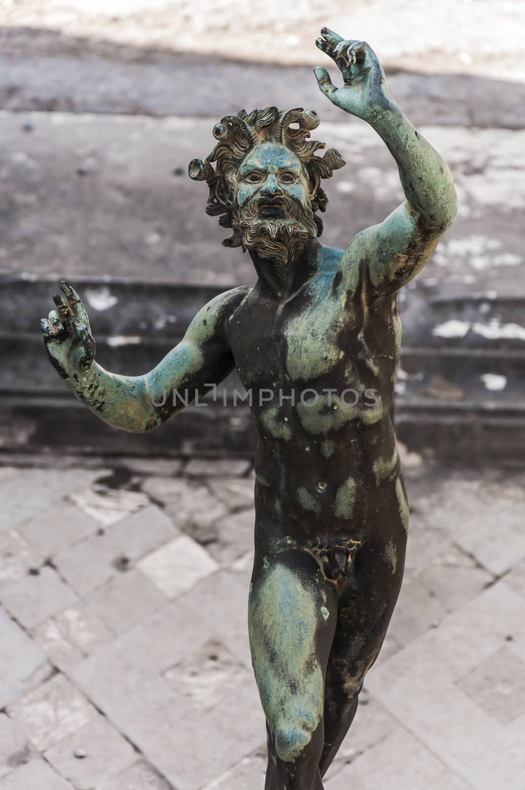 the Fauno bronze statue inside the pompeii ruins, italy