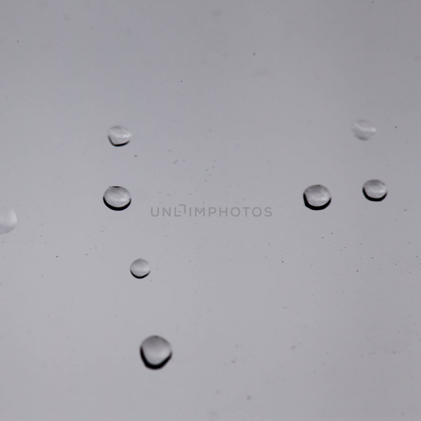 Drops over a glass window, with gray sky behind