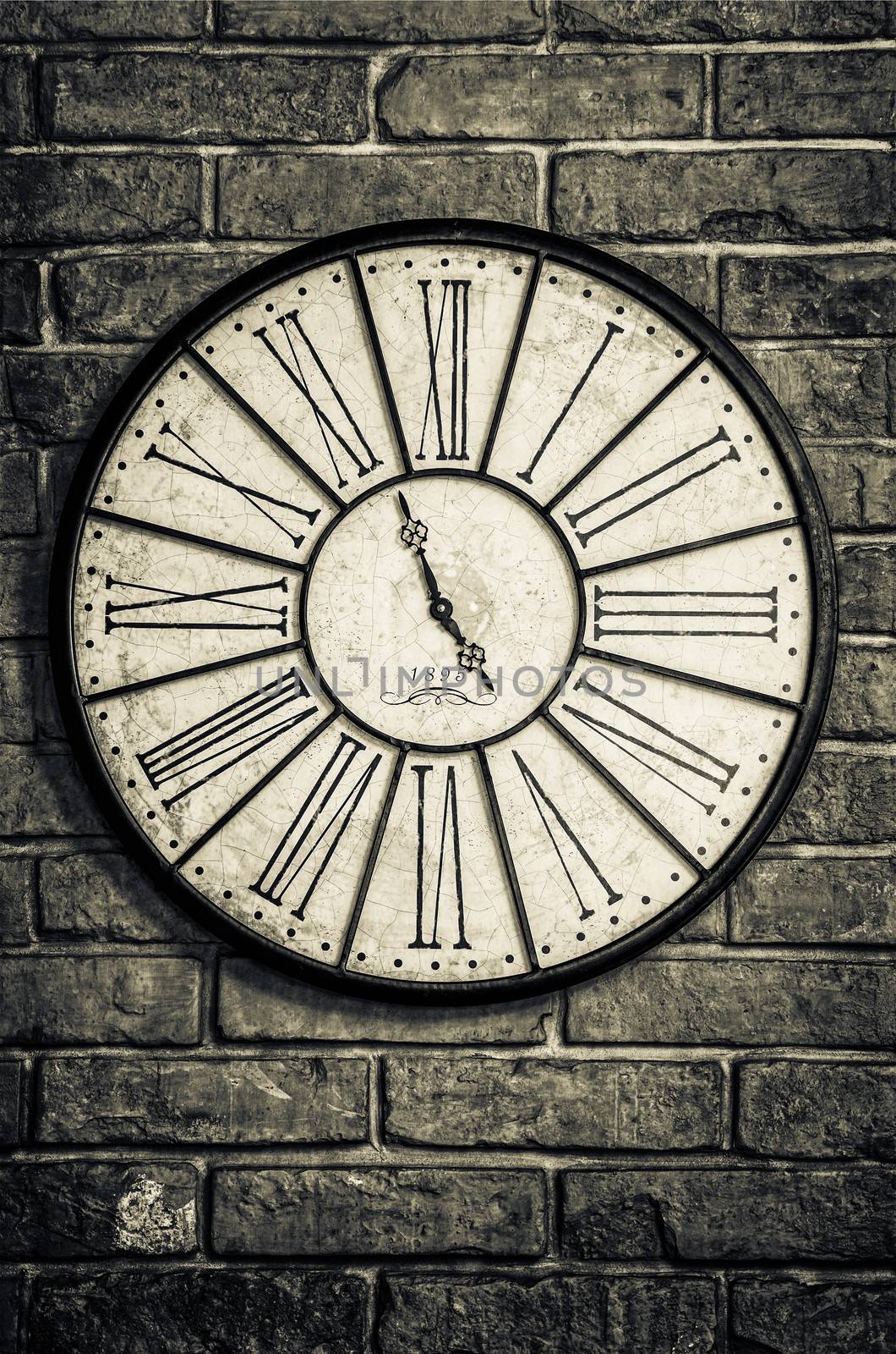 Detail of old vintage clock in monochrome on textured brick wall