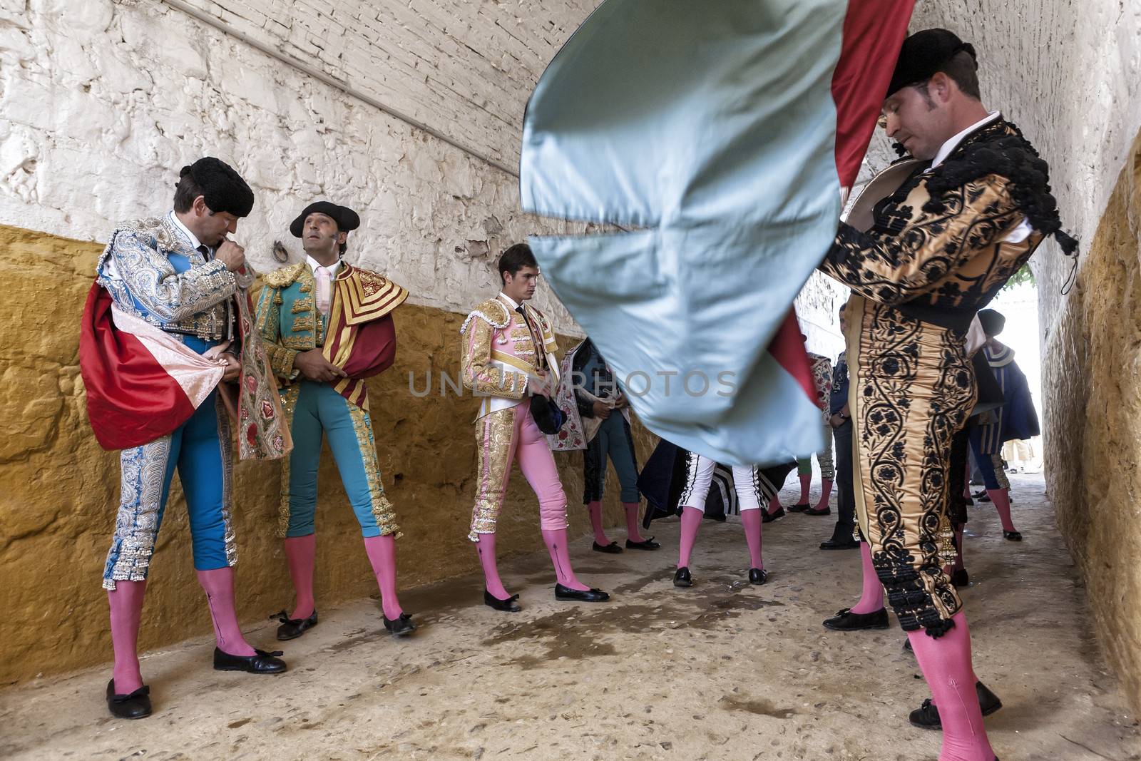 Andujar, Jaen province, SPAIN - 10 september 2011: Bullfighters at the paseillo or initial parade, to the right a bullfighter is trying to catch the capote walk from blue color in the bullfight at Andujar bullring, Andujar, Jaen province, Andalusia, Spain