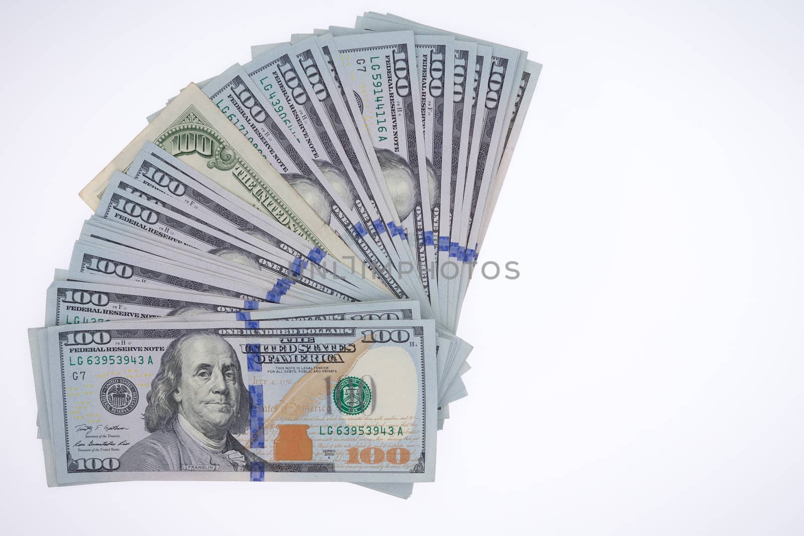 Fanned arrangement of American 100 dollar bills, or Benjamin Franklins, isolated on a white background viewed from above with copyspace