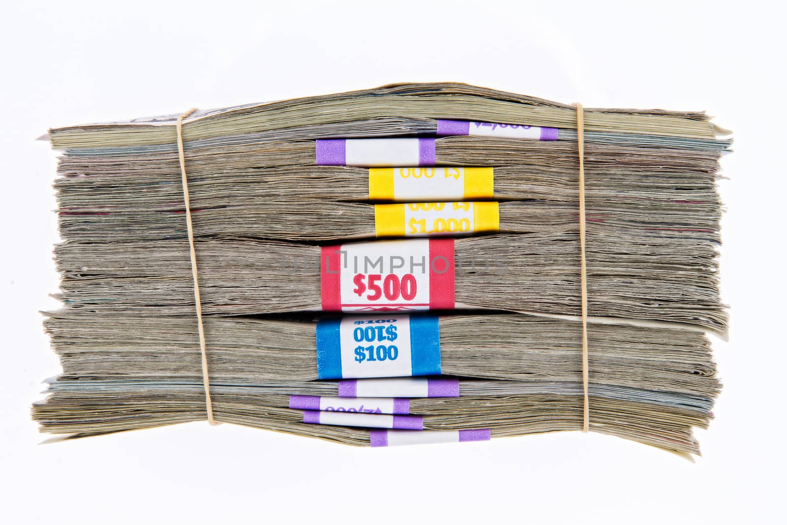 Bank bundles of different denomination dollar bills stacked on top of each other and secured with two rubber bands, side view isolated on white