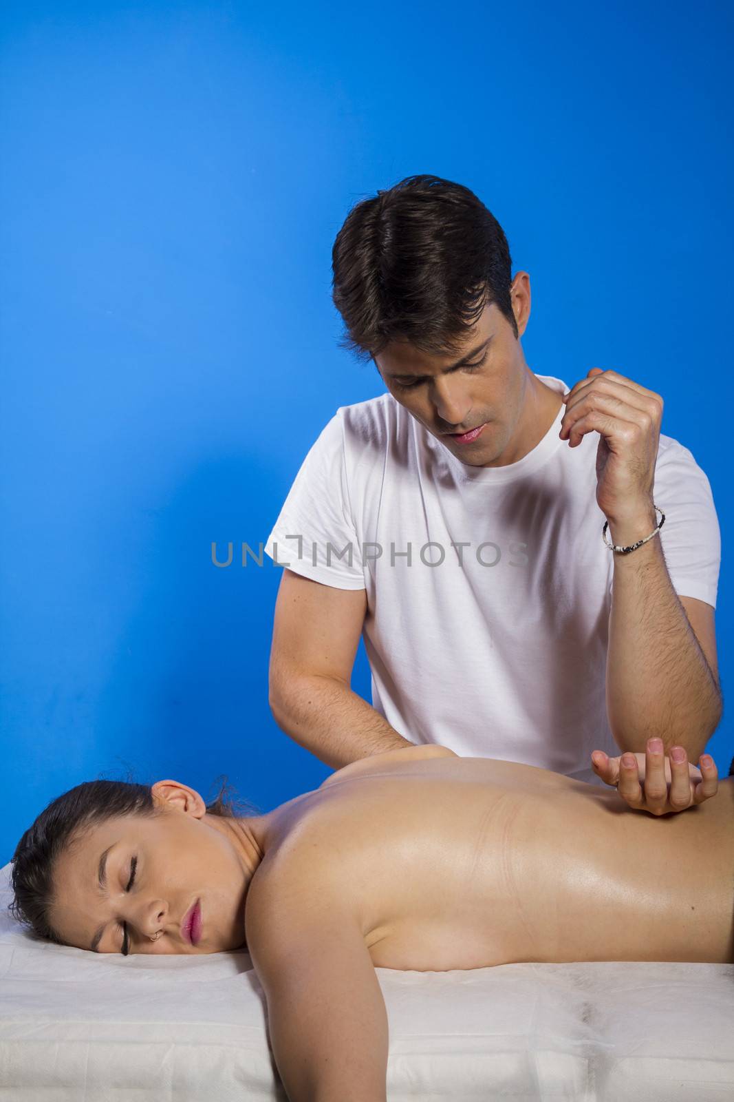 Masseur doing massage on woman body in the spa salon. Beauty treatment concept.