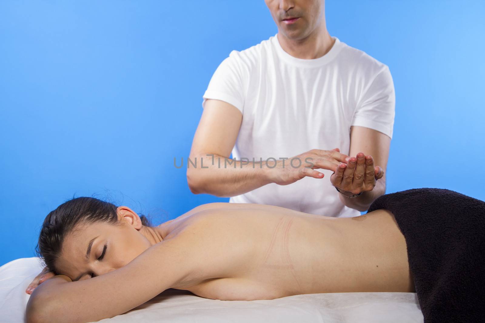 Masseur doing massage on woman body in the spa salon. Beauty treatment concept.