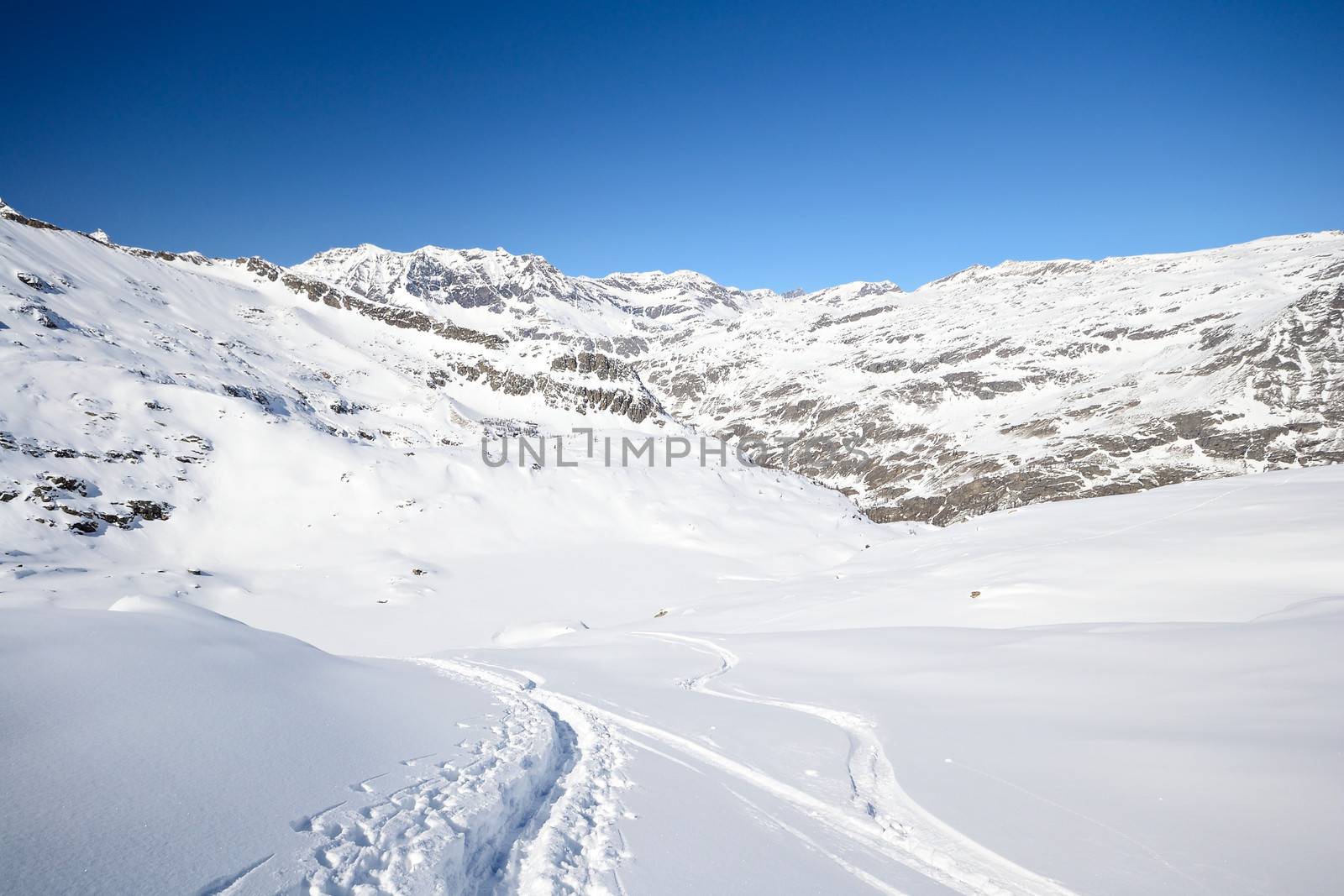 Tour ski tracks on snowy slope in winter scenic landscape