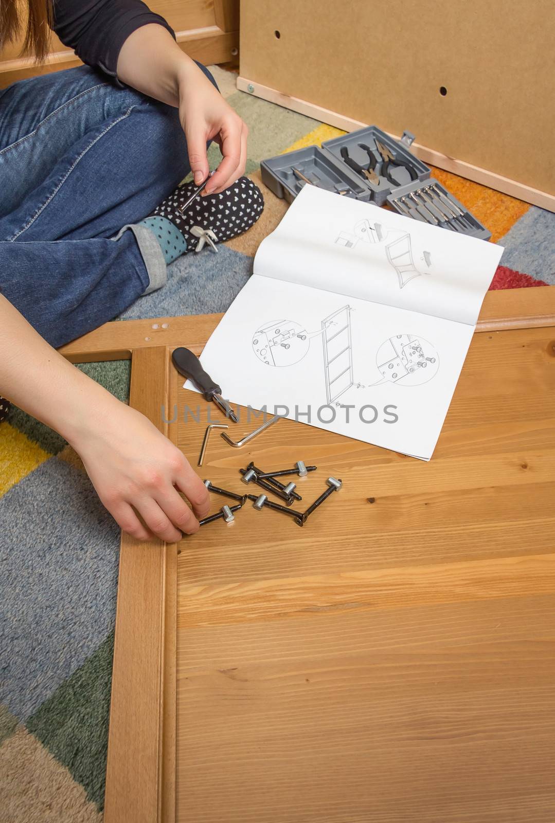 Closeup of girl with tools and instructions ready to assemble a new furniture for home