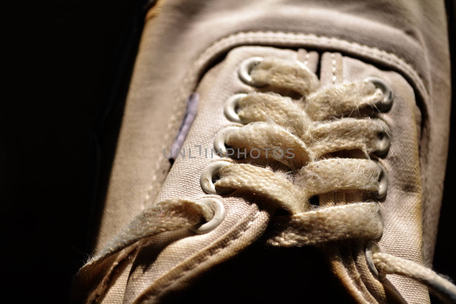 Rope of white sneakers in black background