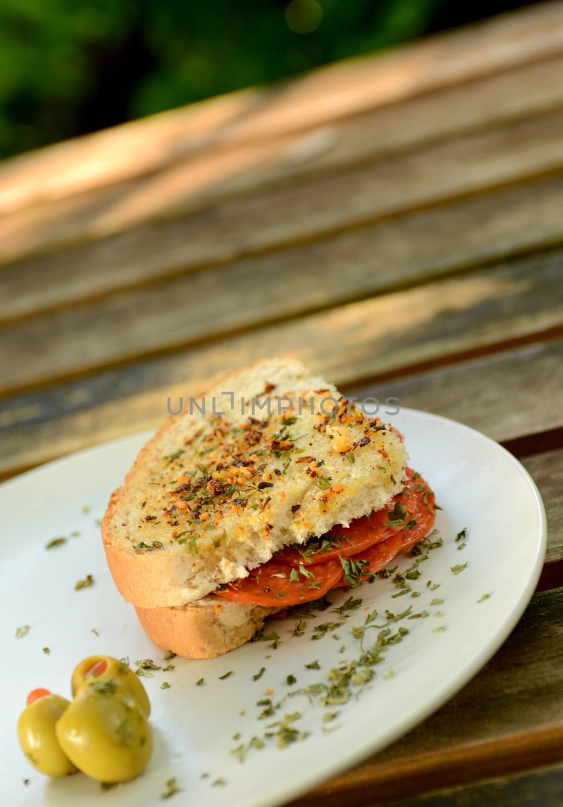 salami sandwich on wood table outdoors