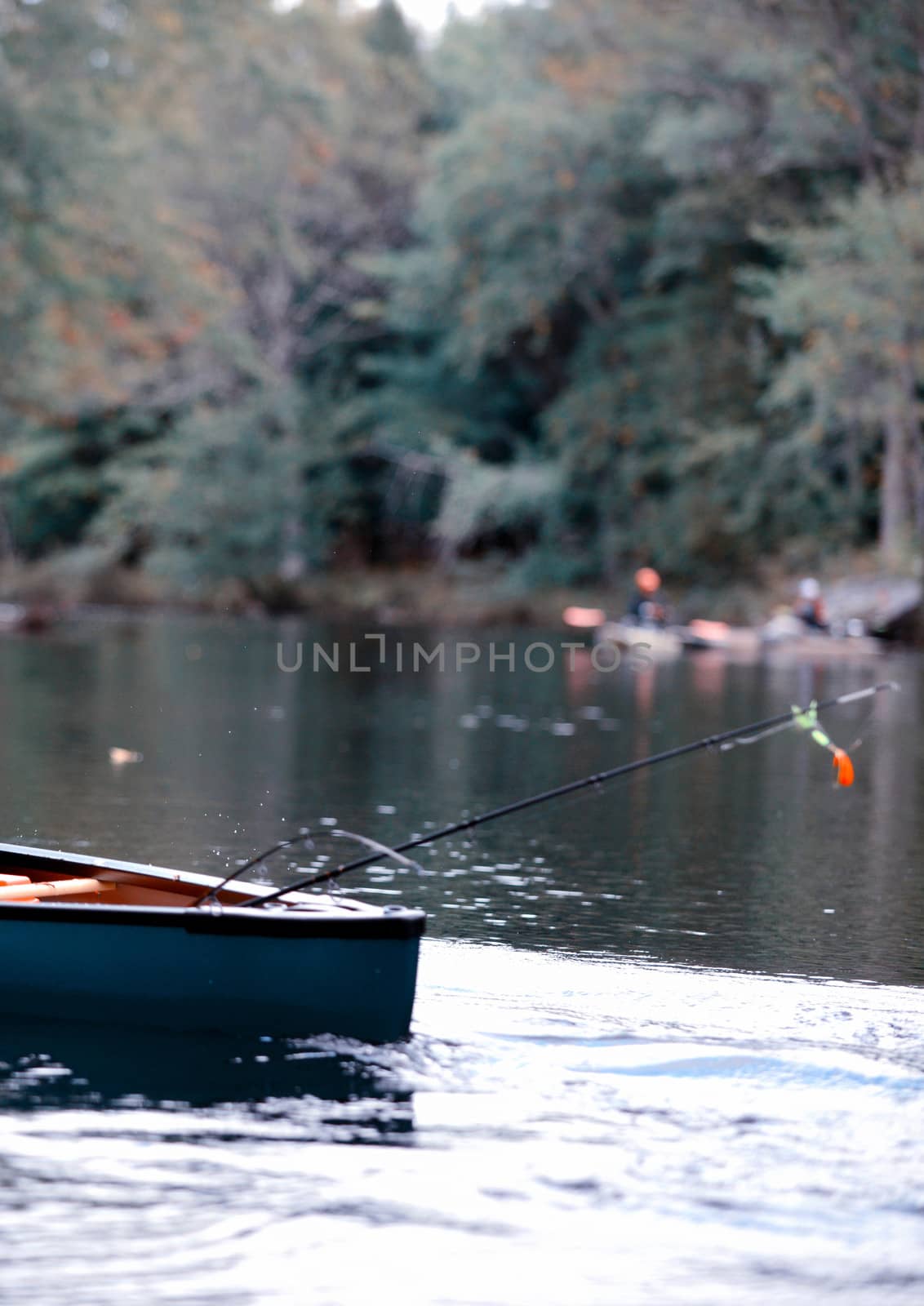 fishing in a canoe with a fishing pole in autumn in Maine
