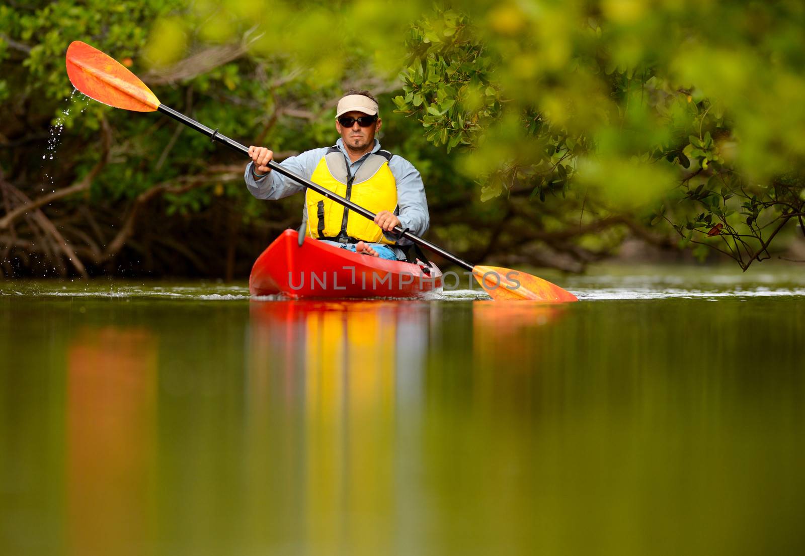 young man in red kayak in tropical destination