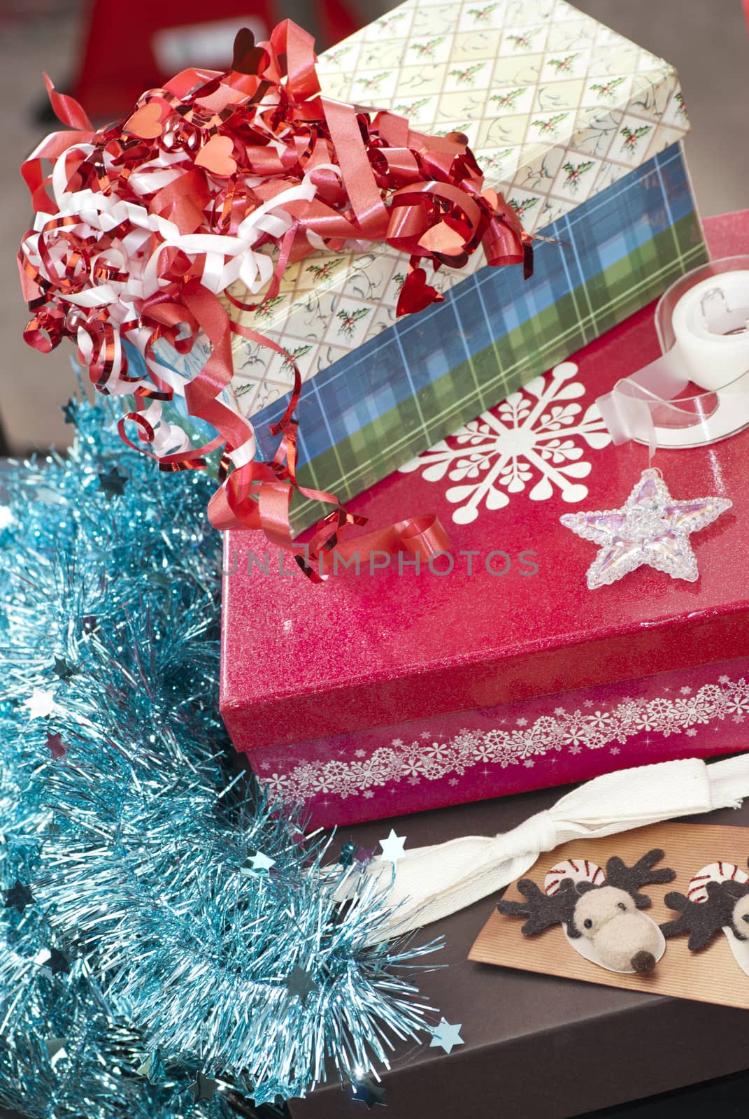 Close-up of boxes, tinsel, wrapping paper, tape and ribbons for christmas gift wrapping.
