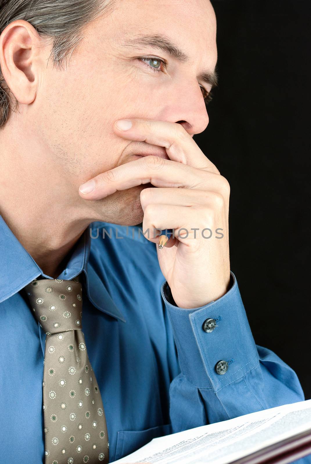 Close-up of a thoughtful businessman contemplating a document.