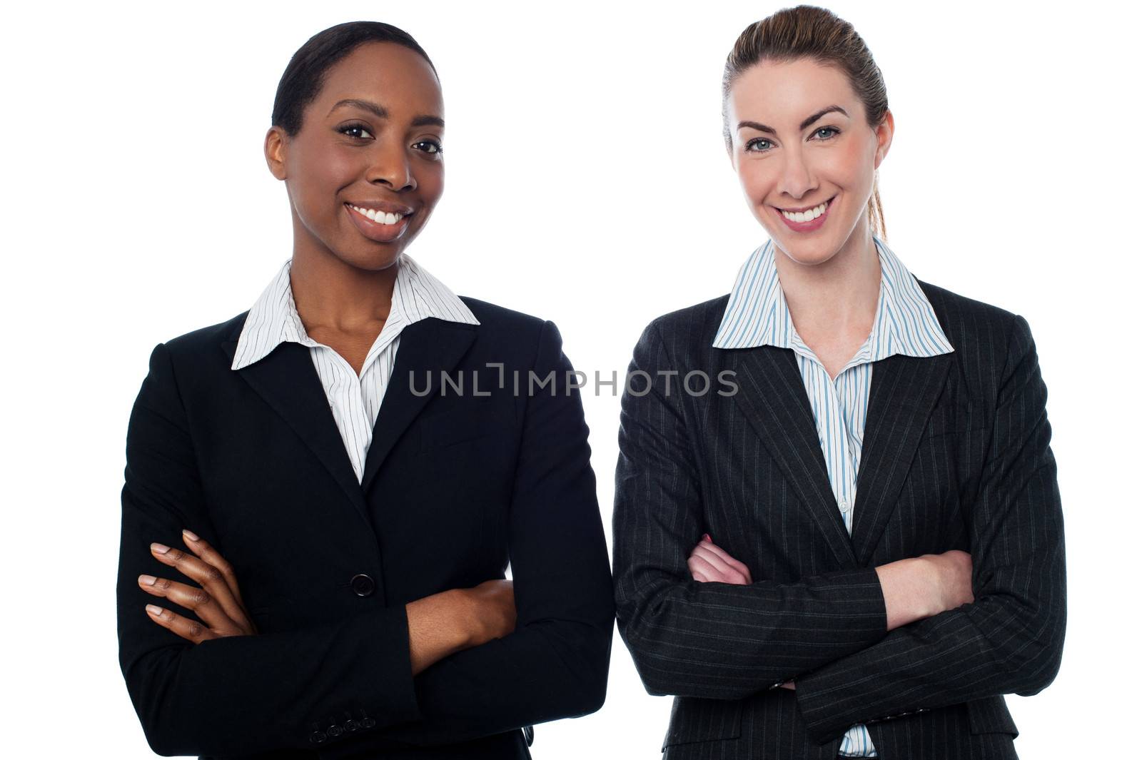 Happy businesswomen with arms crossed by stockyimages