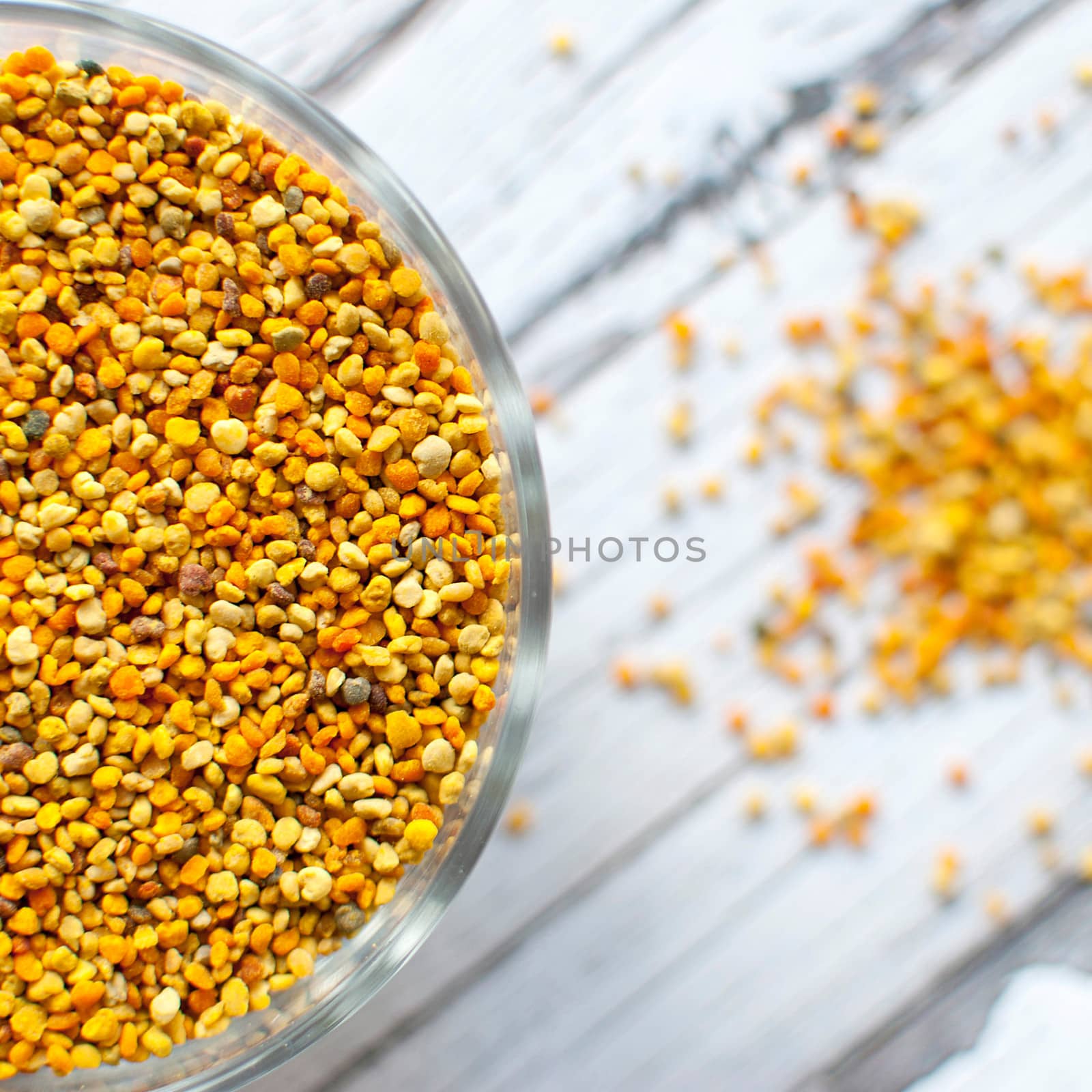 raw organic bee pollen over wooden board