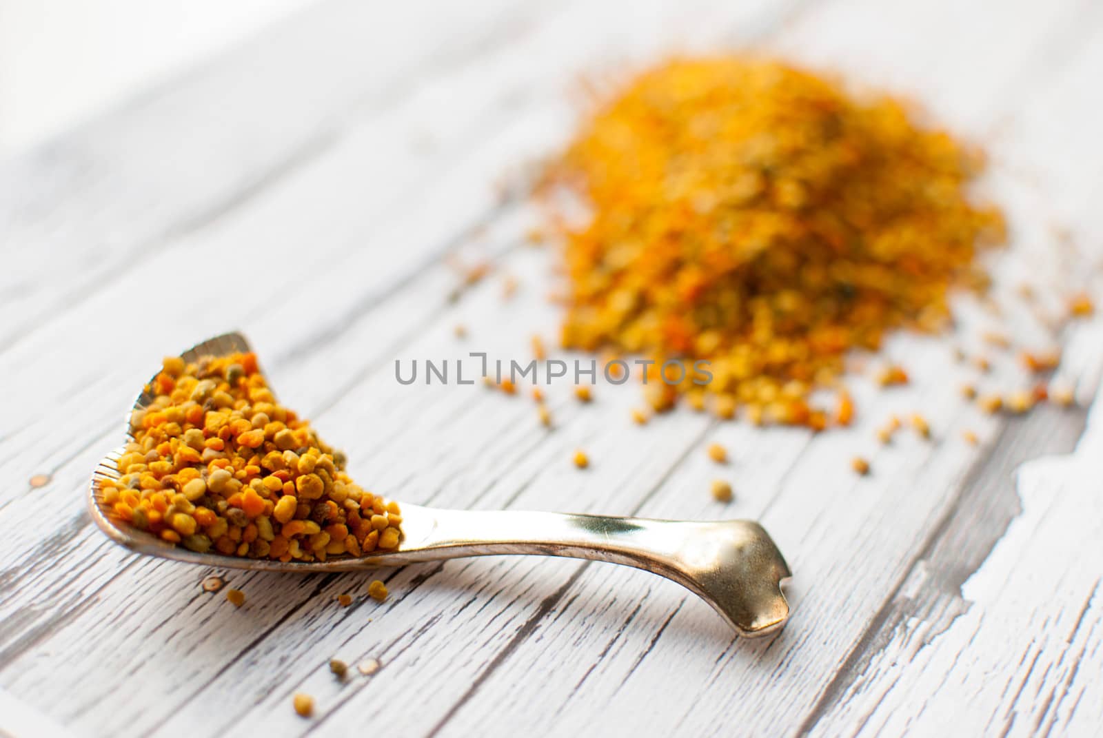 raw organic bee pollen over wooden board