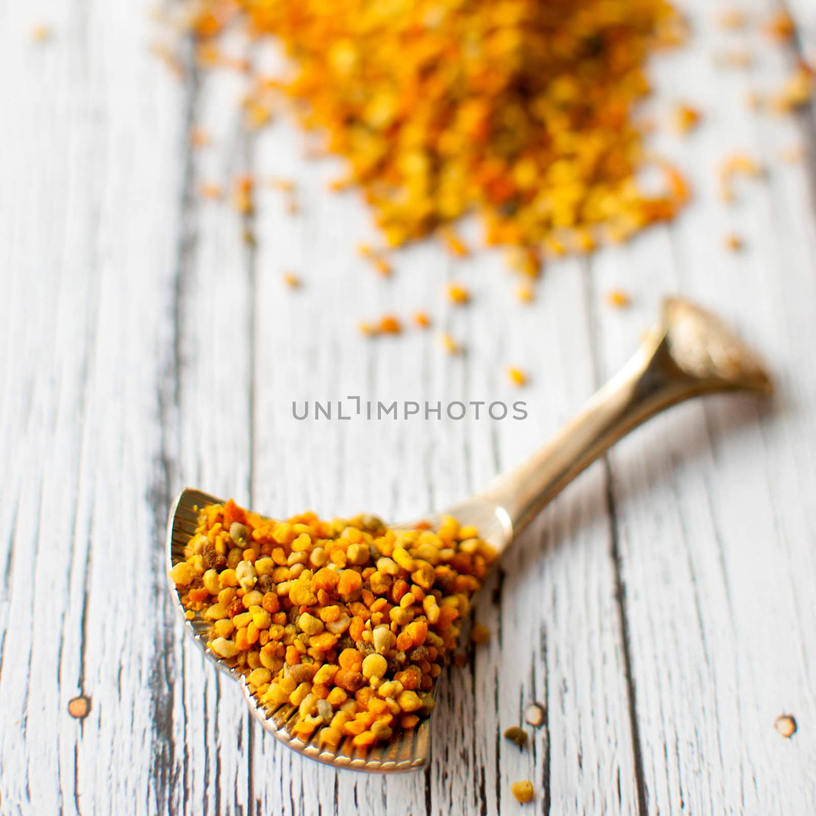 raw organic bee pollen over wooden board