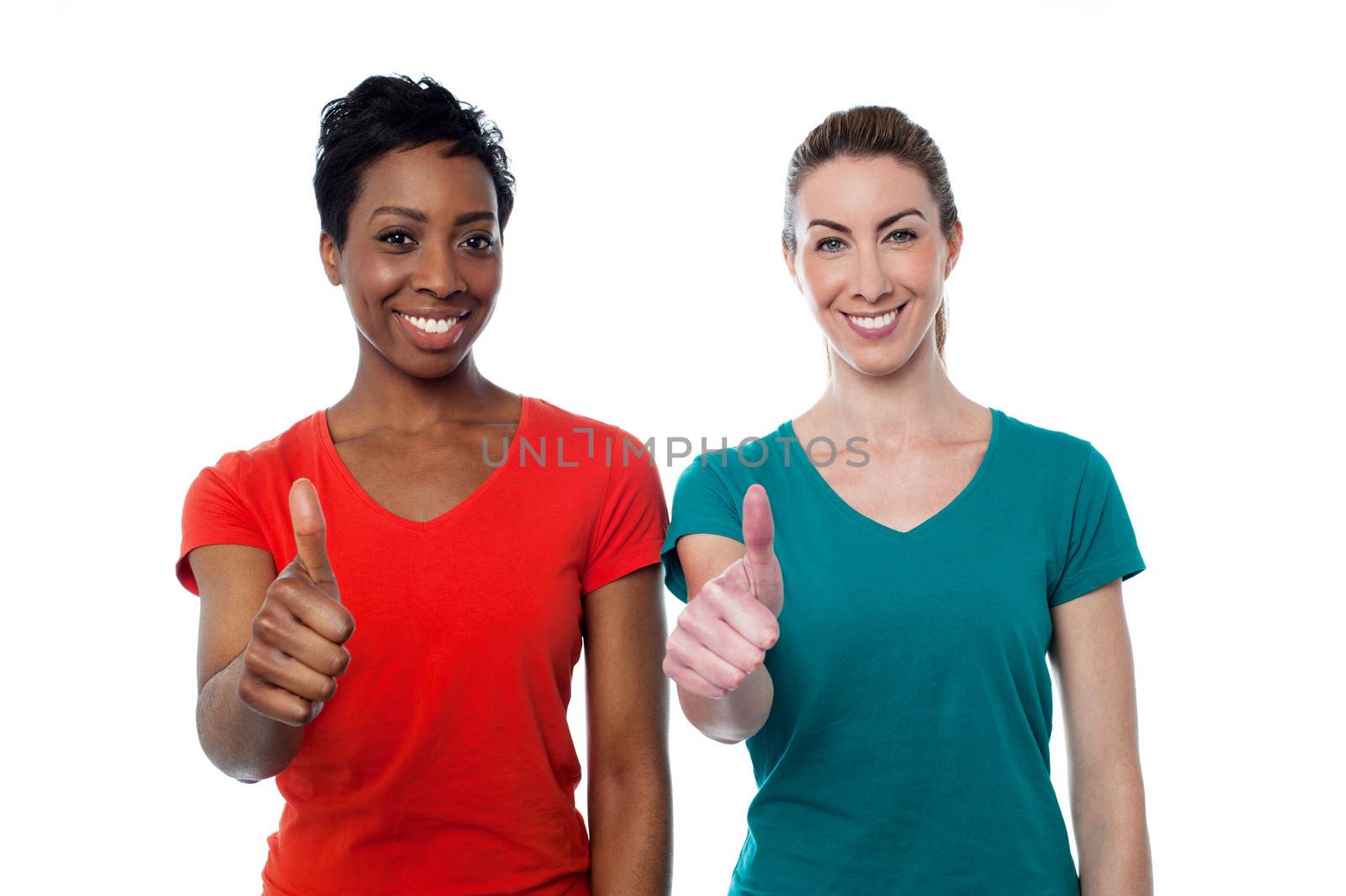 Two happy women with thumbs up by stockyimages