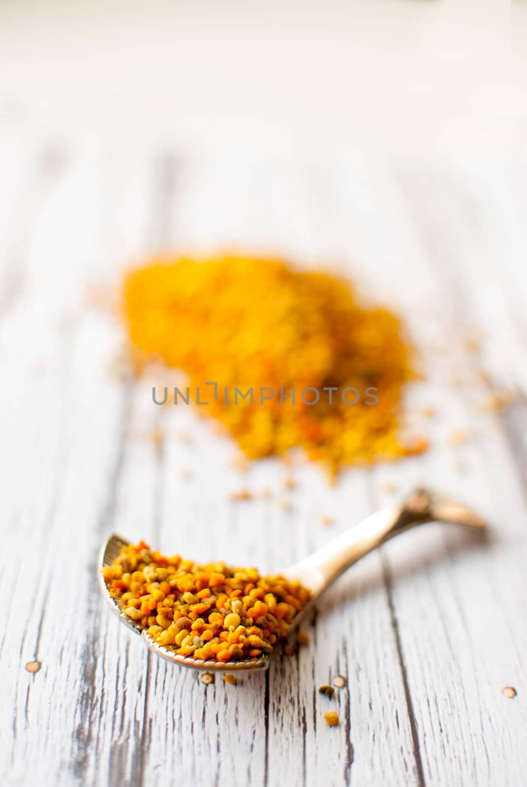 raw organic bee pollen over wooden board