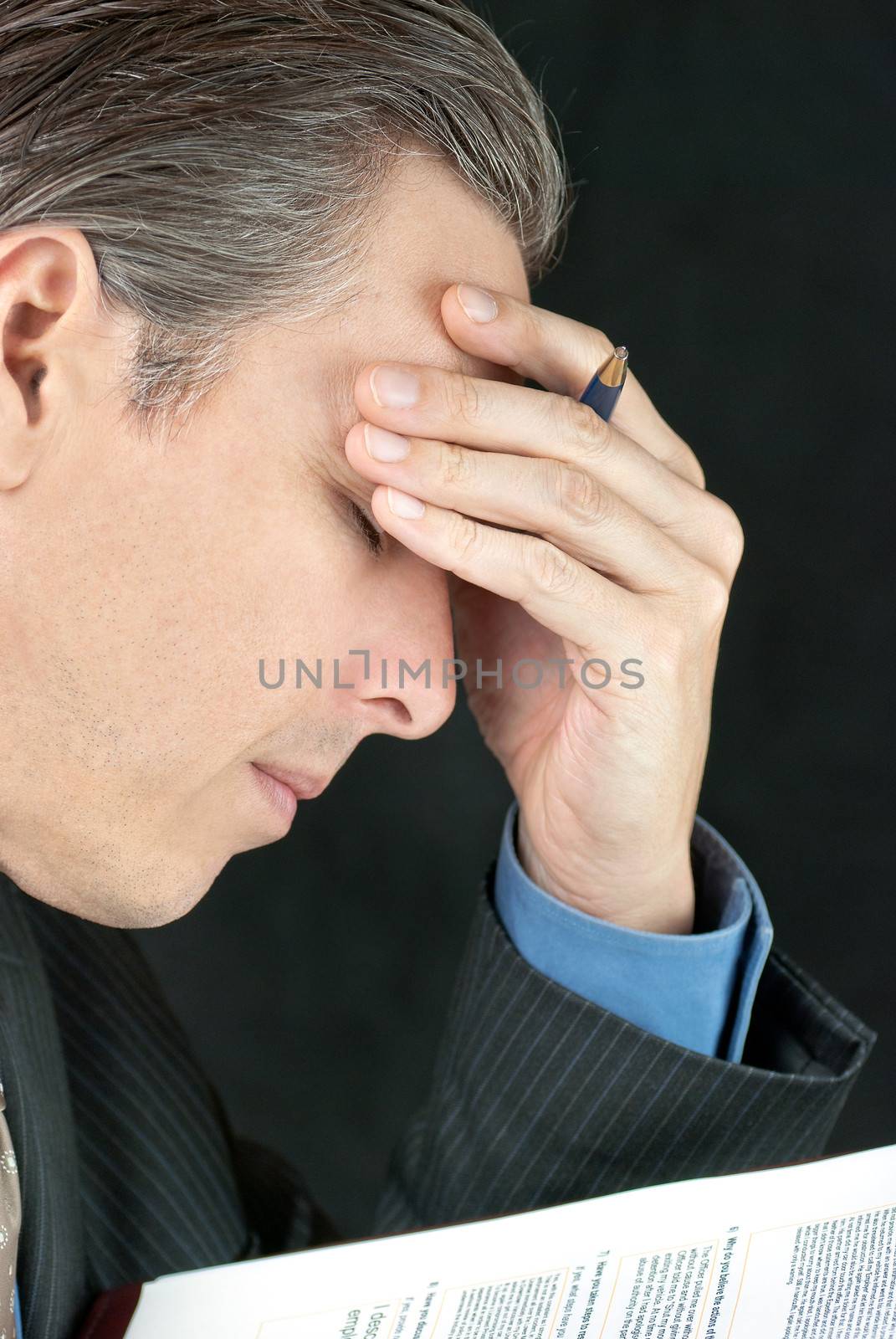 Close-up of a businessman pondering a document.