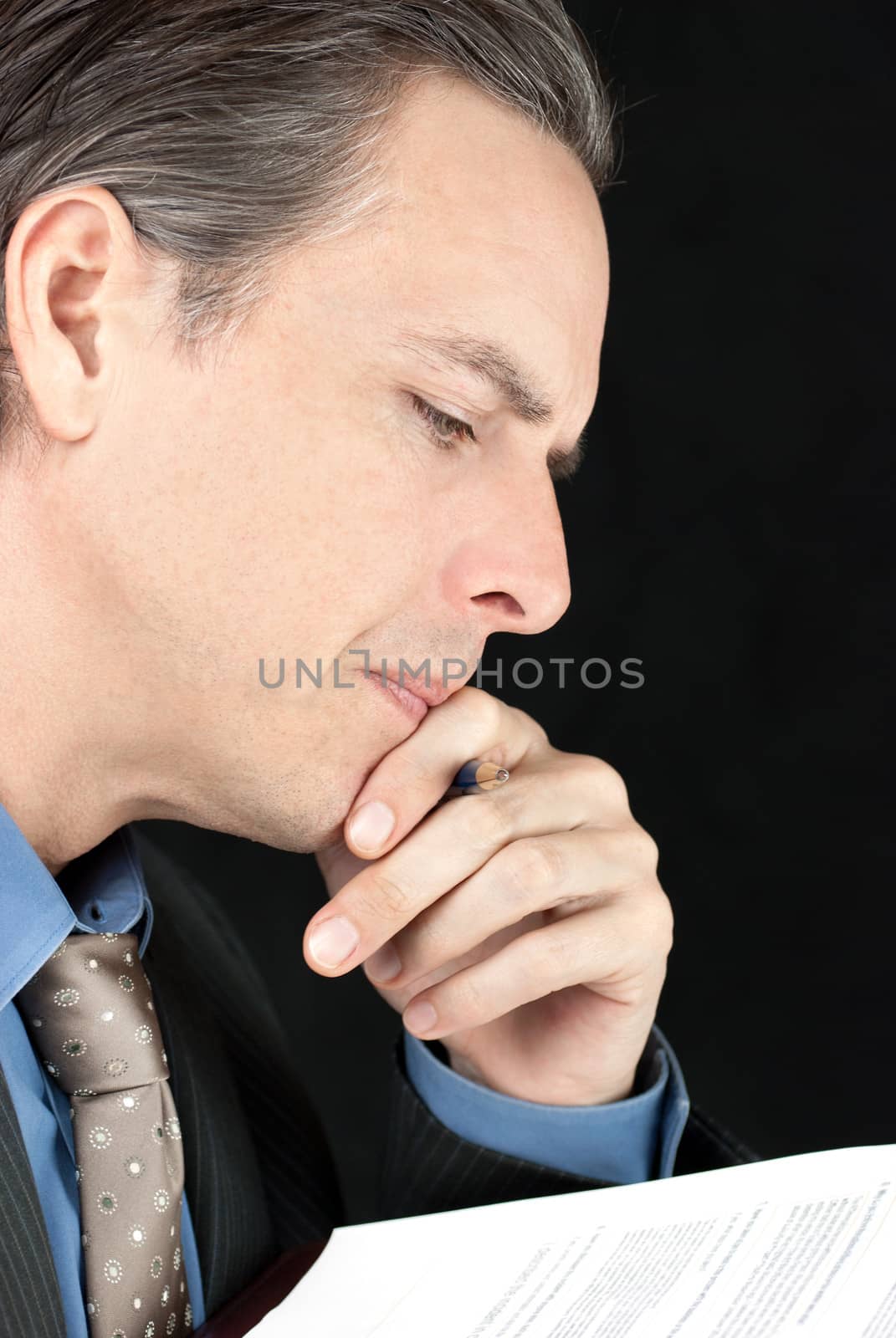 Close-up of a businessman considering a document.