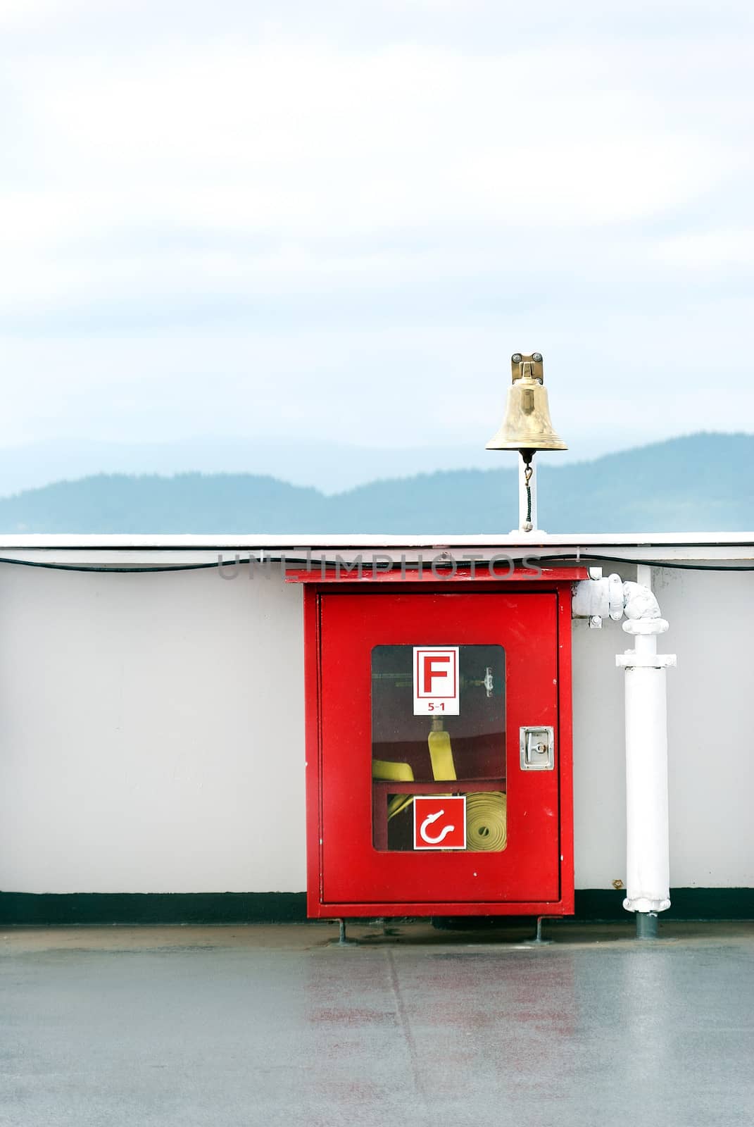 Close-up of a locked, alarmed fore hose box on a bridge. Mountains in the horizon.