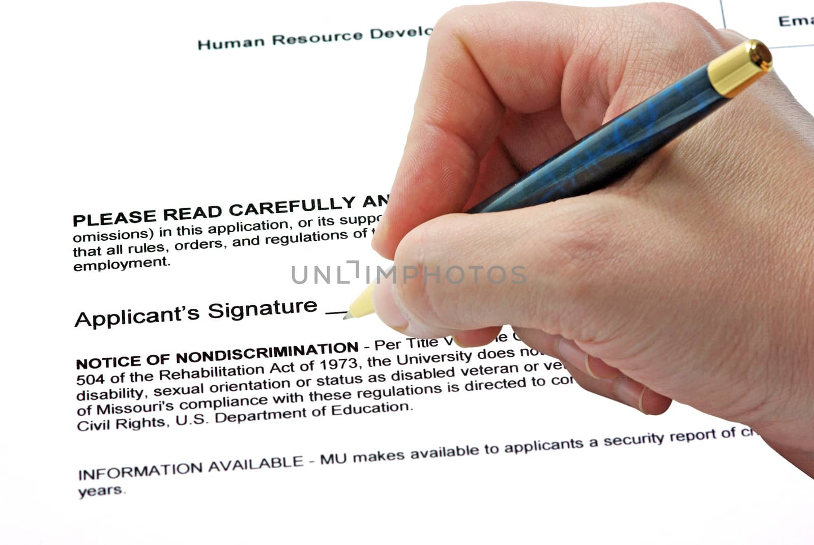 Hand with pen signing on a contract.
