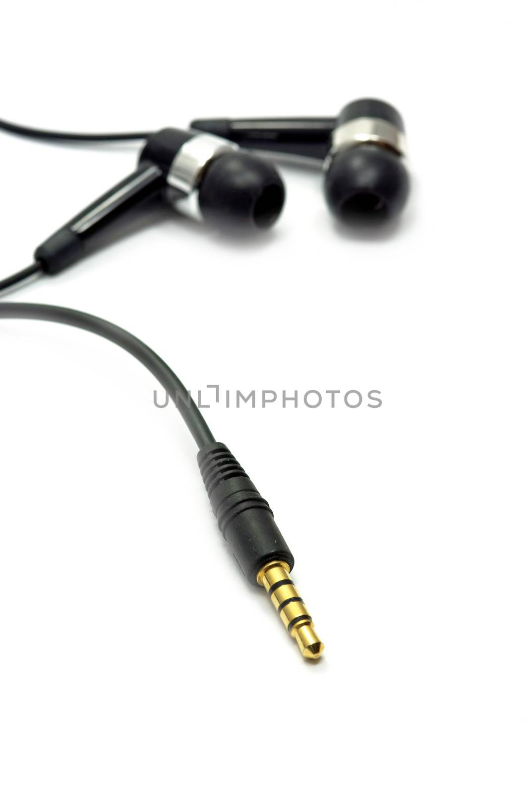 Audio jack and earphone on white (the focus is on the jack).