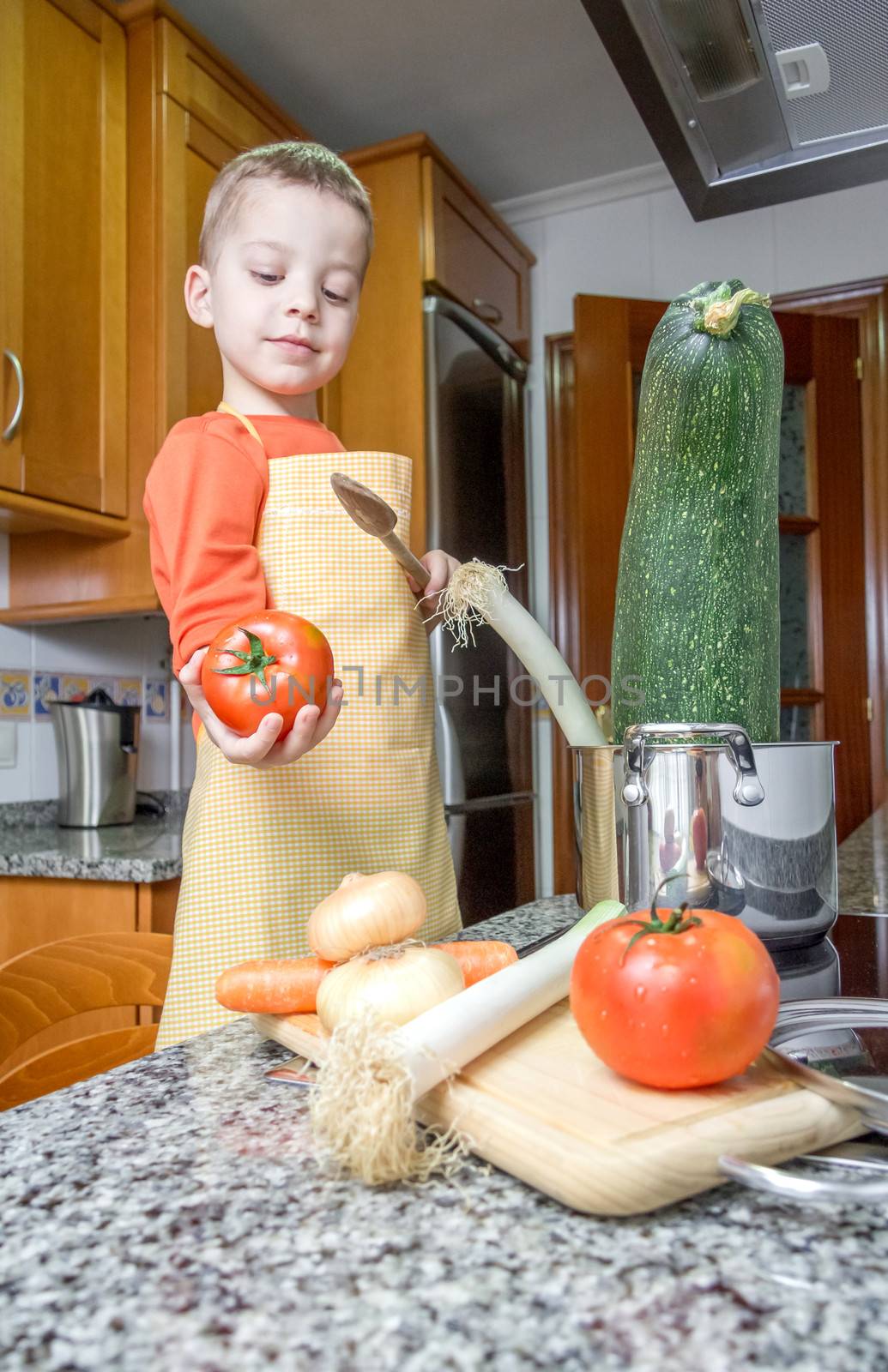 Cute child chef cooking big zucchini in a pot by doble.d