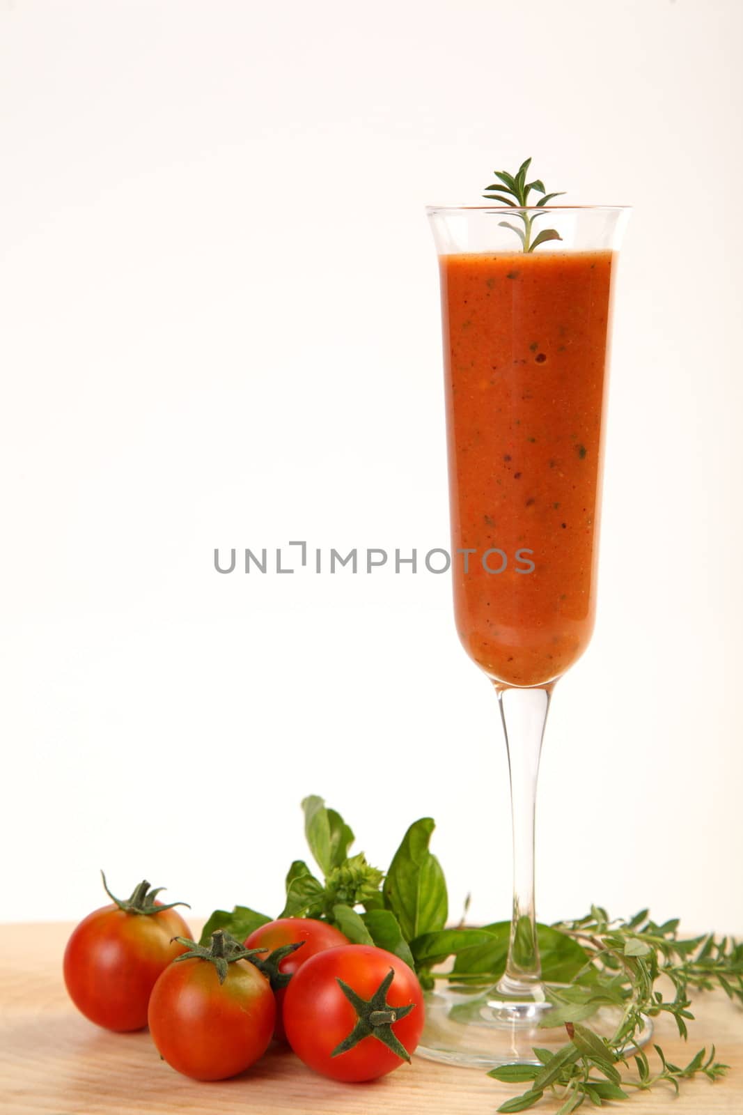 Tomatoes cold soup served on glass with basil