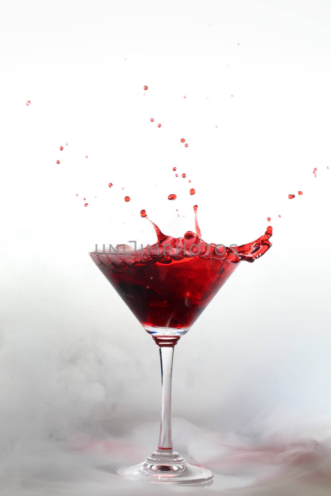 Vertical photo of a splash colored drink with smoke
