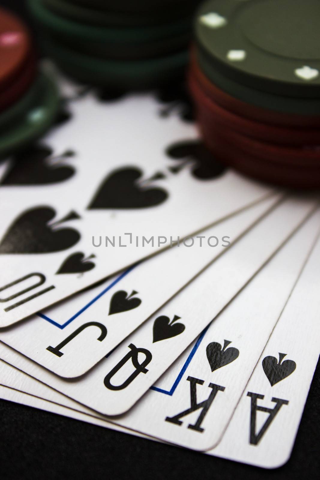 Cards laying around with poker chips on top.