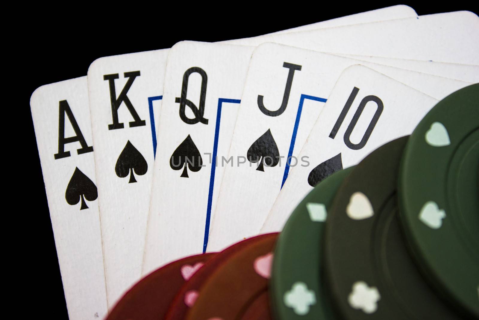 Cards laying around with poker chips on top.