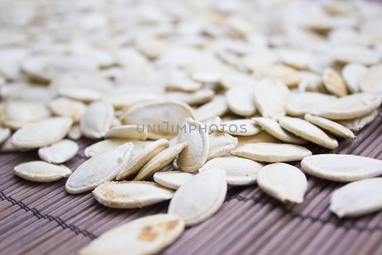 Closeup on toasted pumpkin seeds laying around.