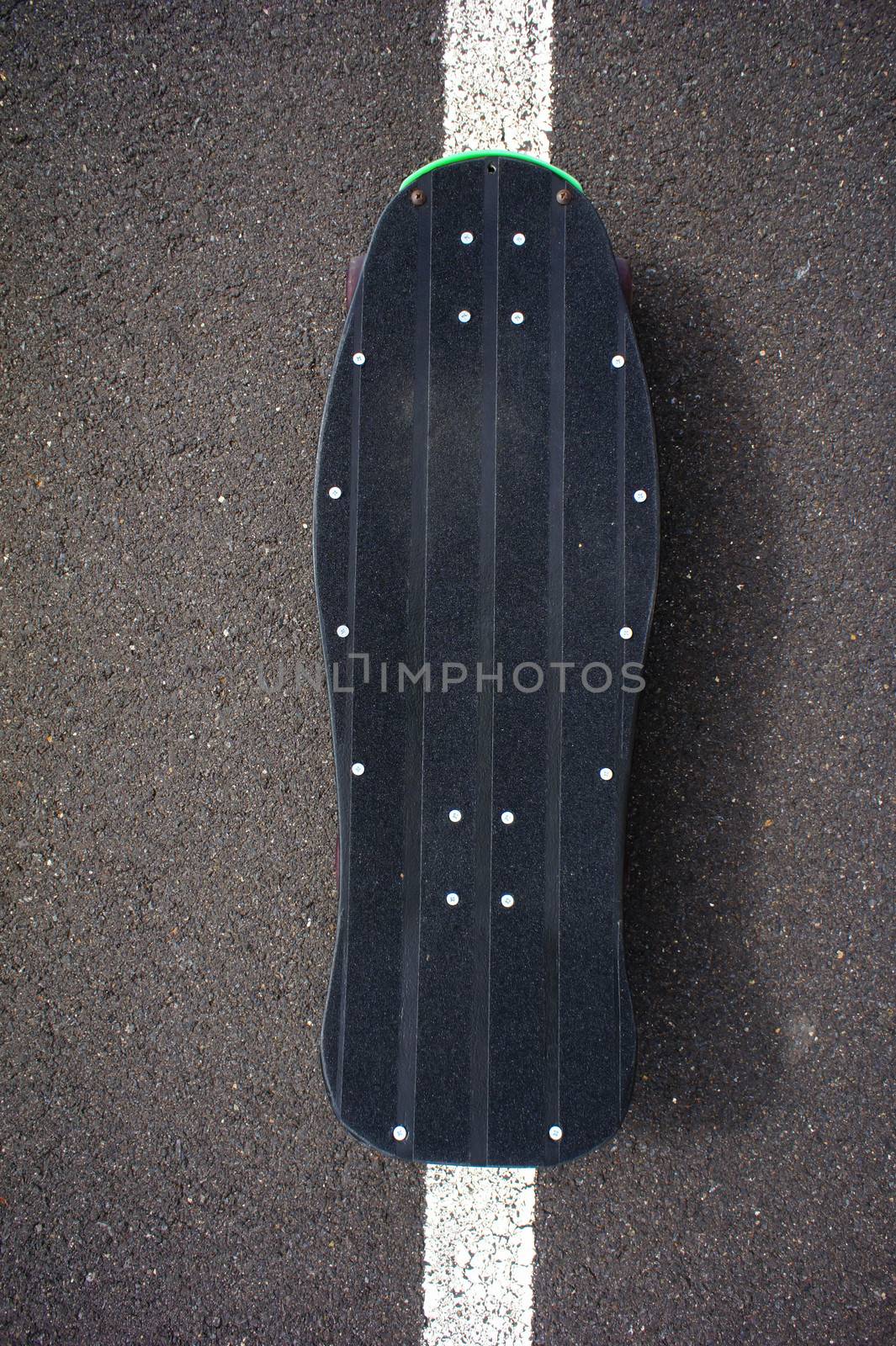 Vintage Style Longboard Black Skateboard on an Empty Asphalt Desert Road