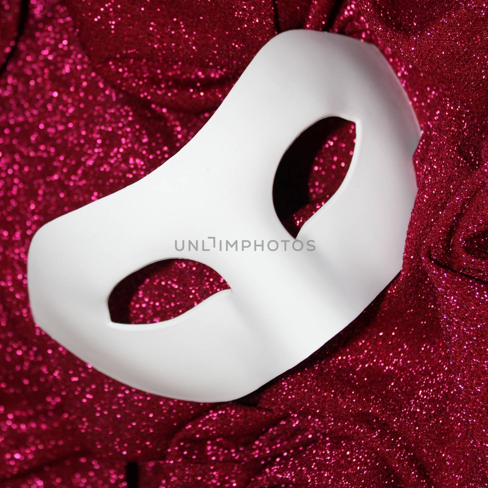 White carnival mask on pink glitters