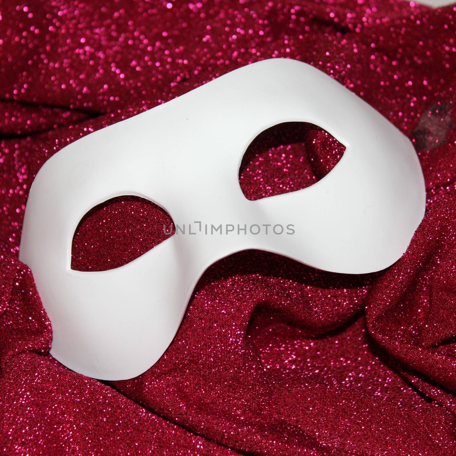 White carnival mask on pink glitters