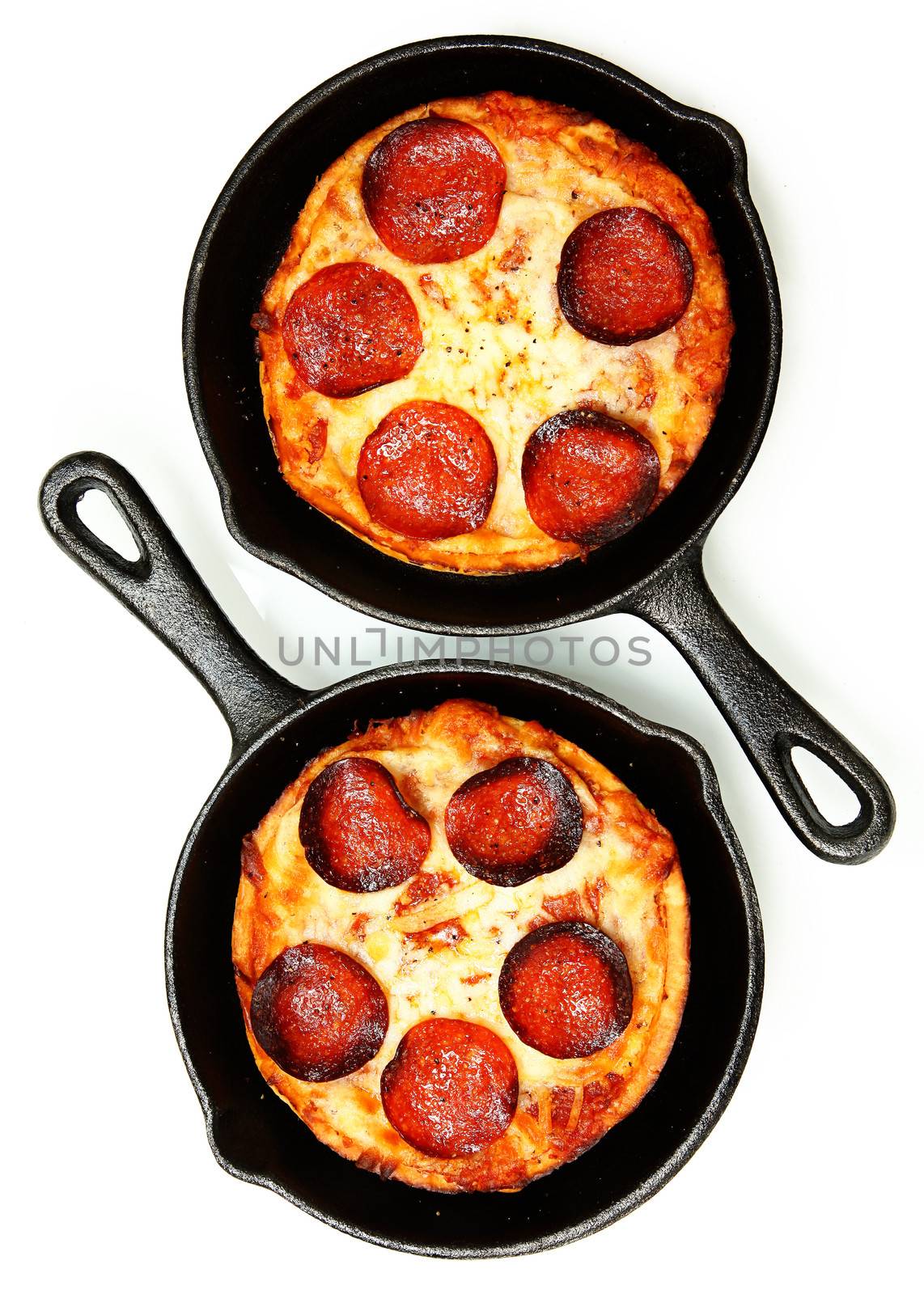 Two Single Serve Skillet Peperonni Pizzas Over White by duplass