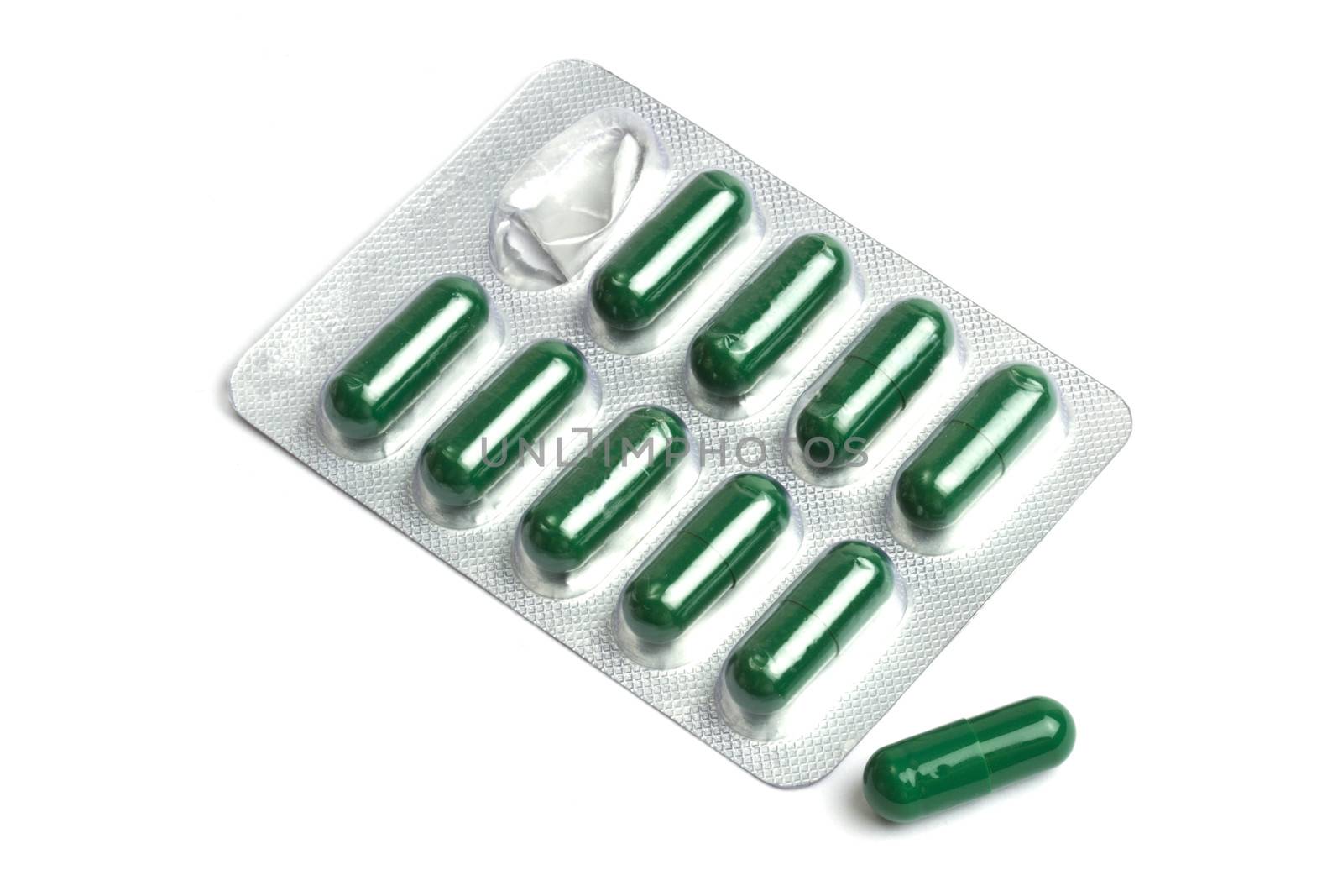 Green capsules packed in blister isolated on white 