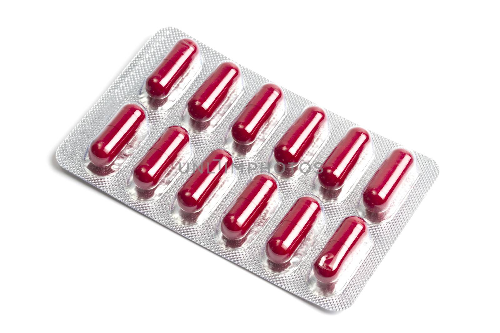 Red capsules packed in blister isolated on white 