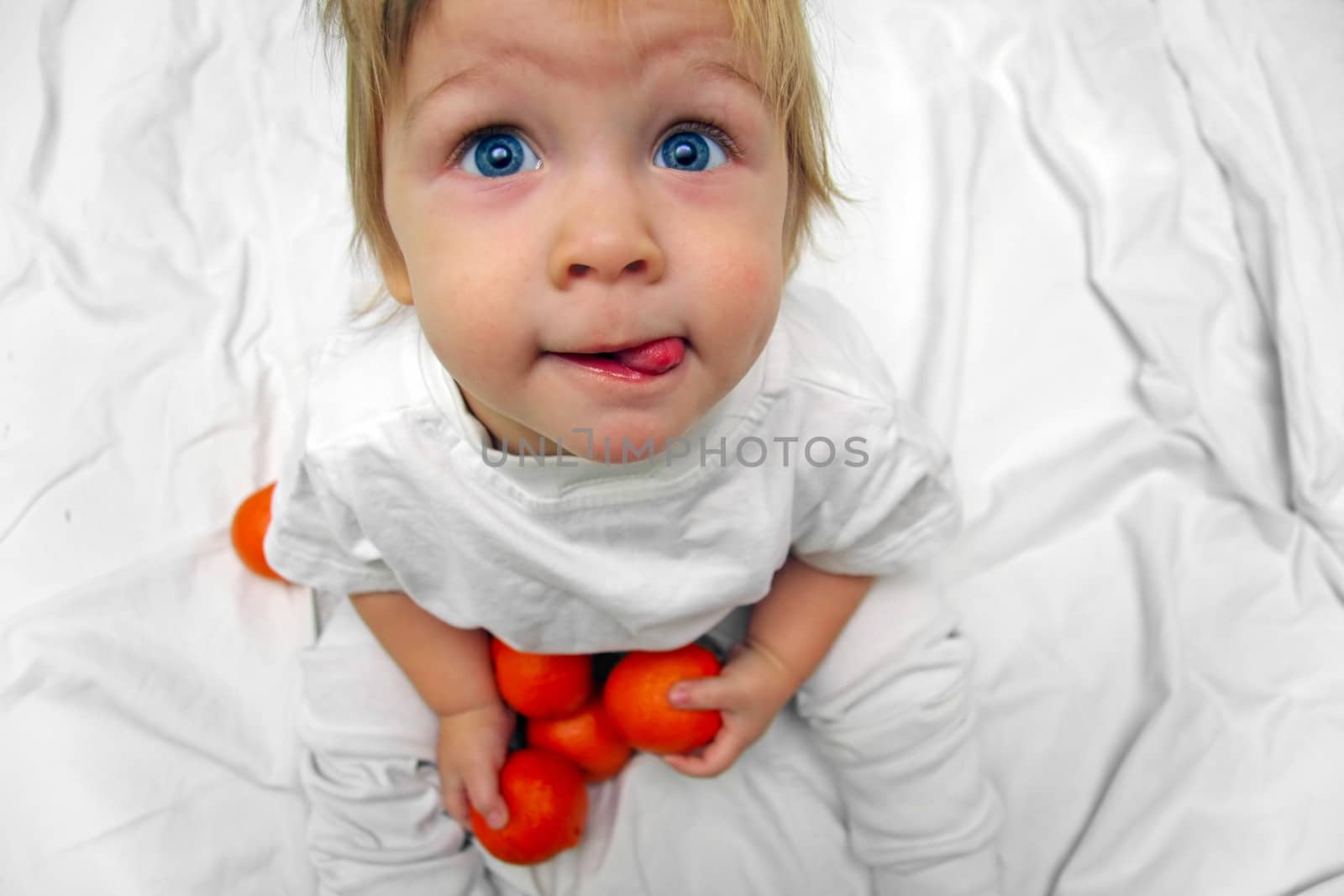 little boy with oranges licked