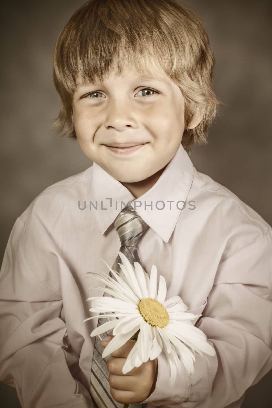 handsome boy wearing classic suit with flowers in hands