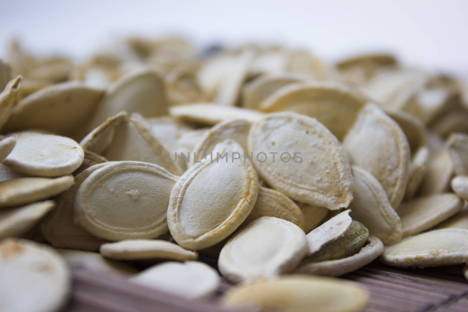 Closeup on toasted pumpkin seeds laying around.