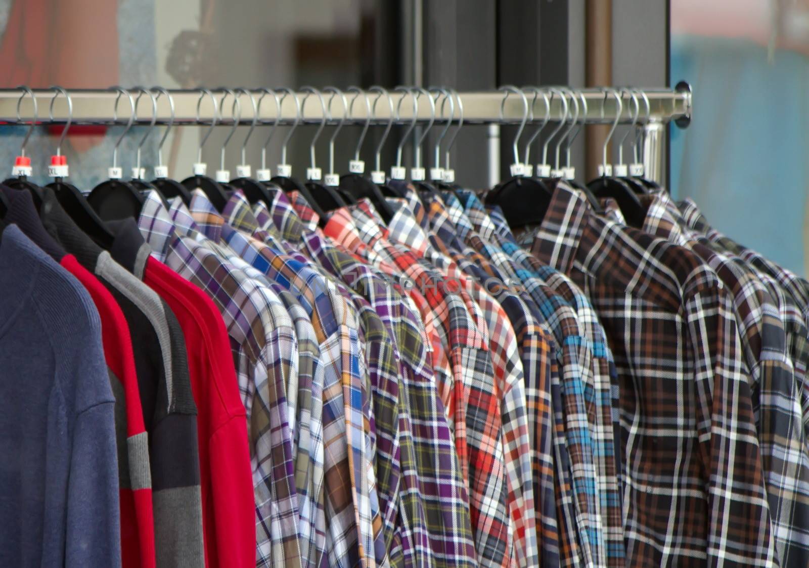 Close up on many colorful hanging male shirts