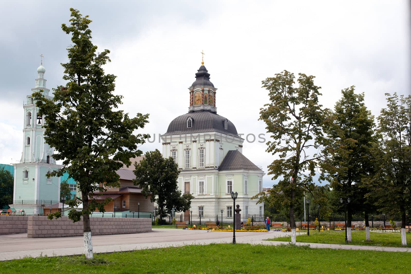 White and green orthodox church with grey domes
