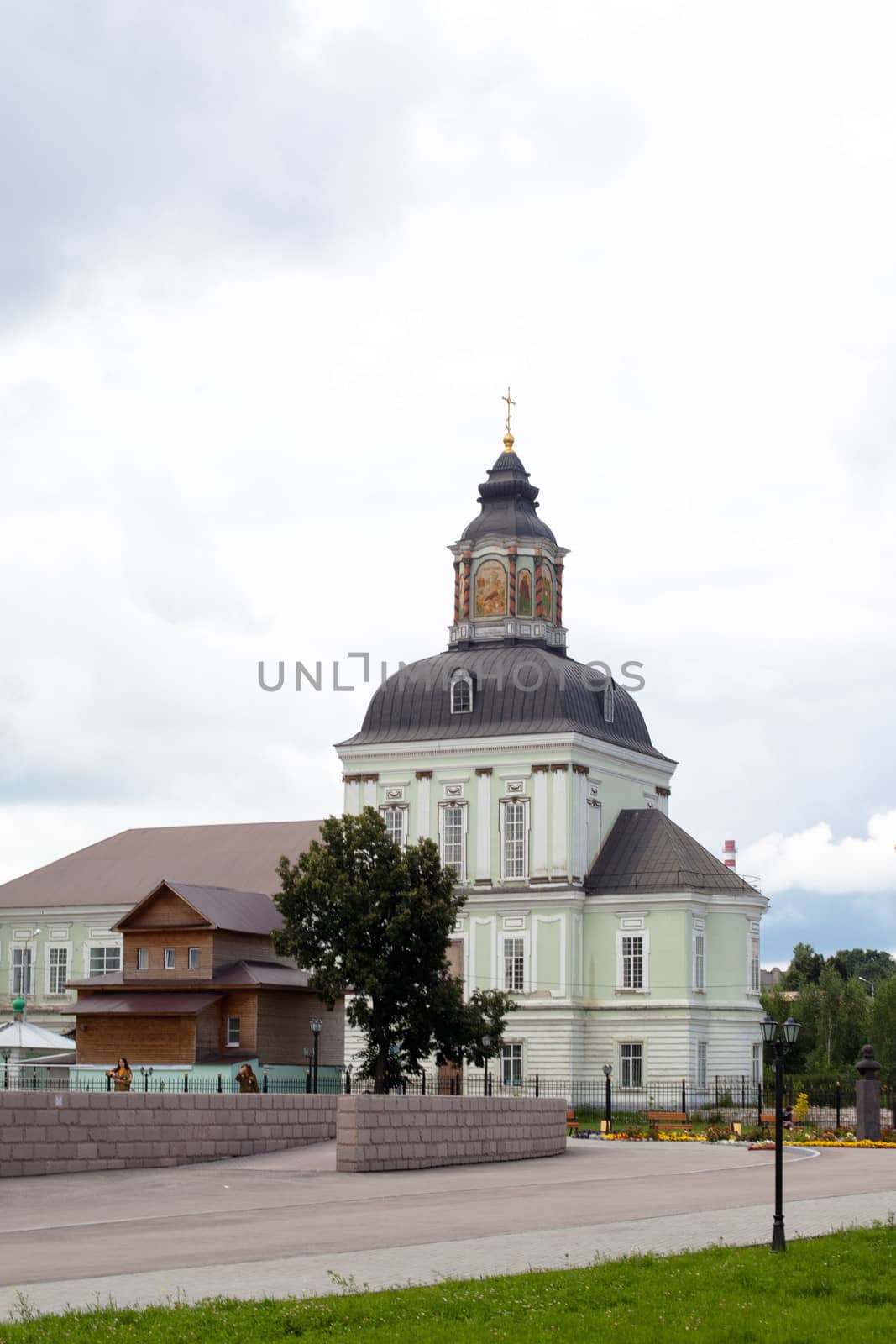 White and green orthodox church with grey domes
